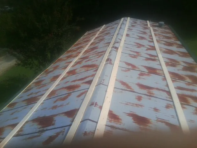 Rusted metal roof panels with new wood purlins before replacement — Storm Damage Roof Repair in Emlenton by Roofing Brothers