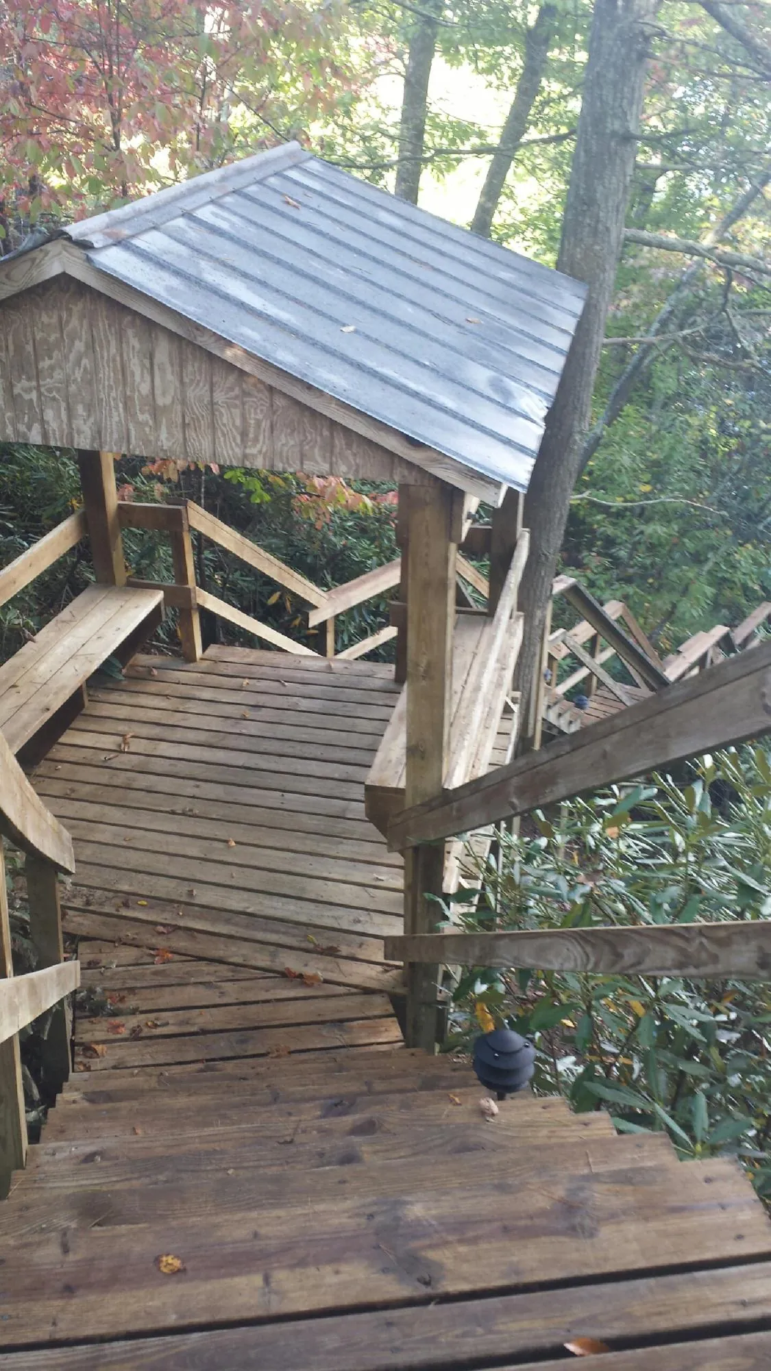 Metal roofed shelter over wooden steps on a wooded walkway — Skylight Repair & Installation work by our crew in Emlenton
