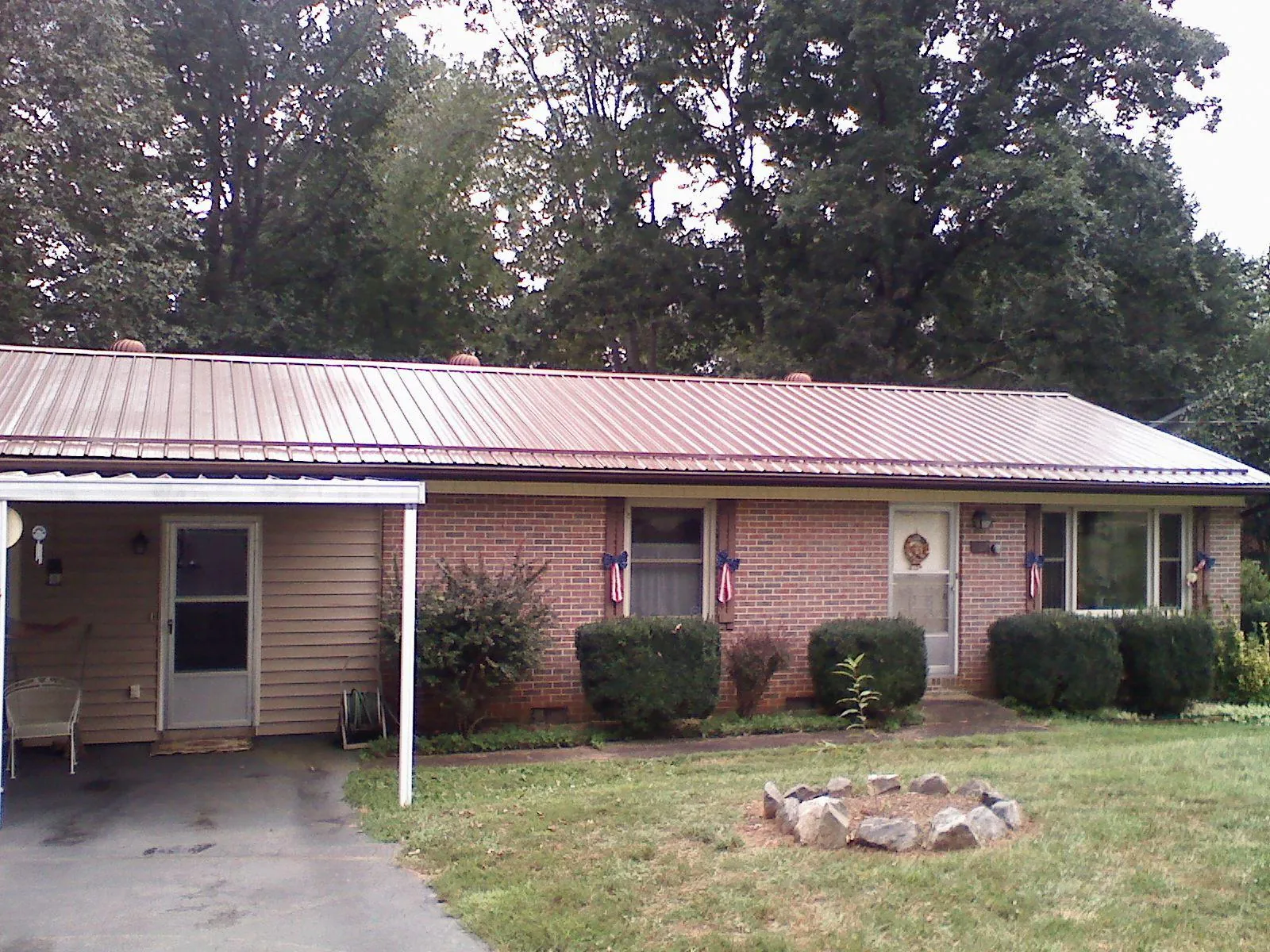 Bronze metal roof and carport on a brick ranch home — Roof Repair work by our crew in Emlenton